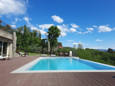 Piscina in cemento armato infinity pool con pavimento in Wpc - PLAYPOOLS PISCINE LUCCA